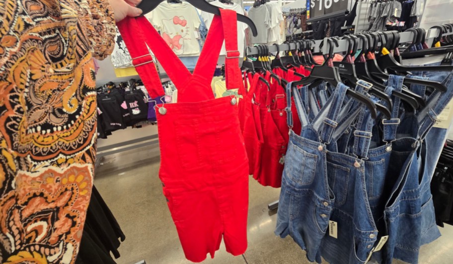 red denim No Boundaries Denim Shortalls on a hanger
