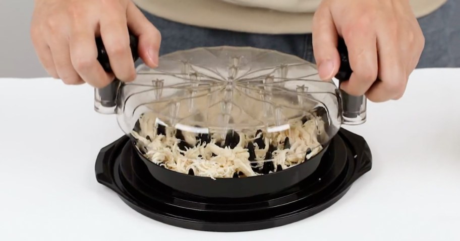 person using a chicken shredder on a kitchen counter