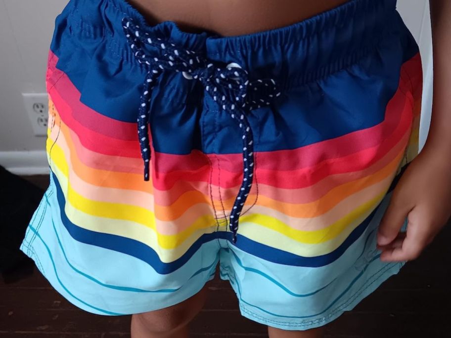 A boy wearing a pair of Angel Season Boys Swim Trunk