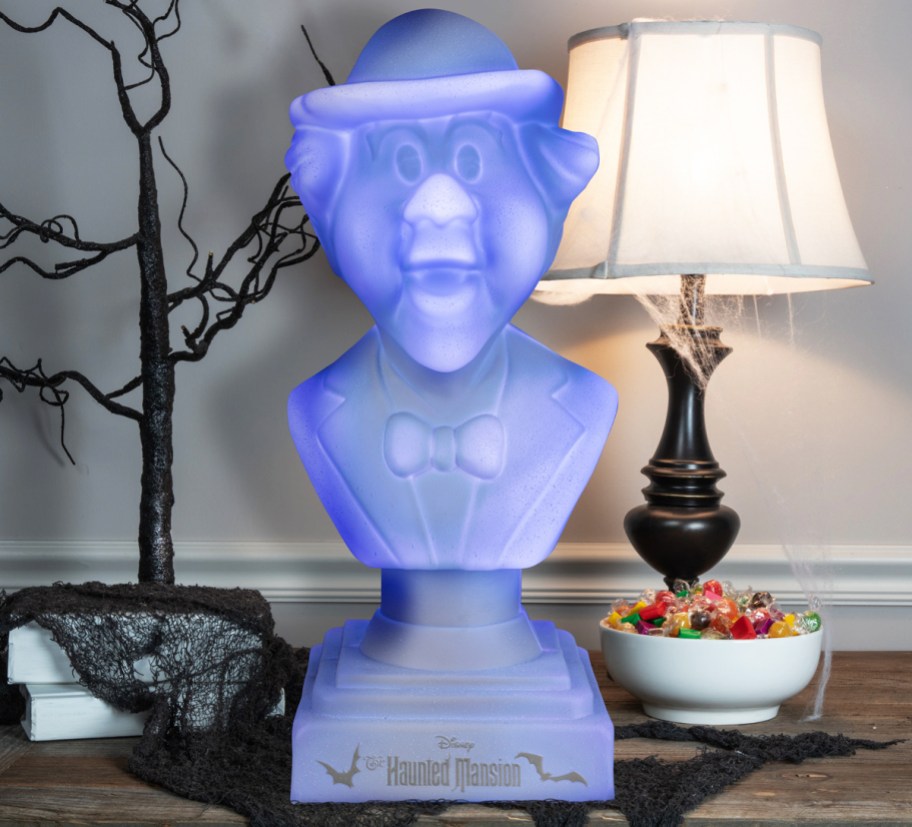 purple lighted bust of Haunted Mansion Cousin Algernon on table near lamp and decorative tree