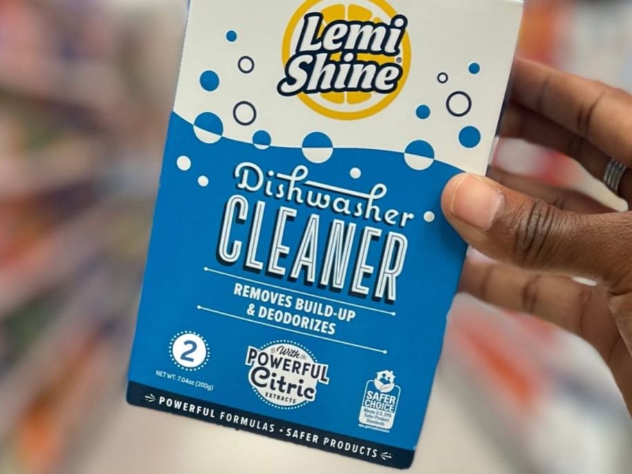 Hand holding a pack of Lemi Shine Dishwasher Cleaners