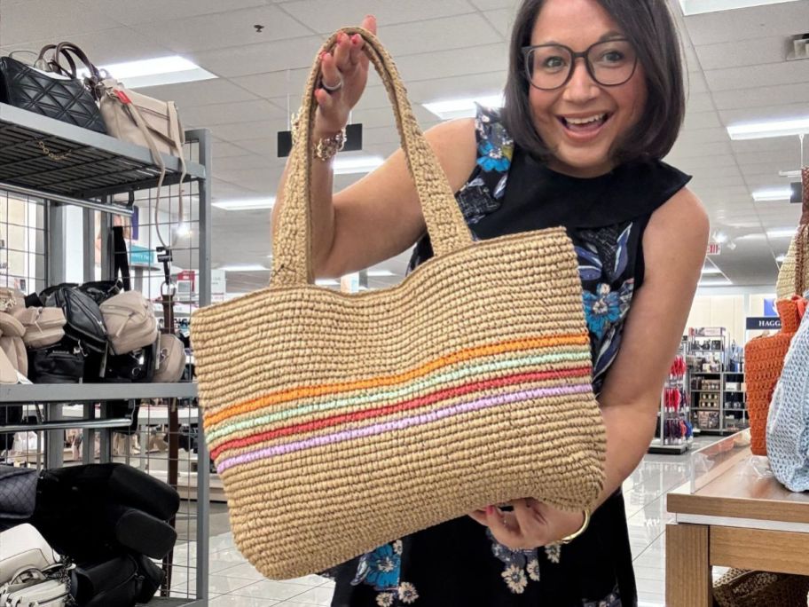 A woman holding a straw bag with stripes
